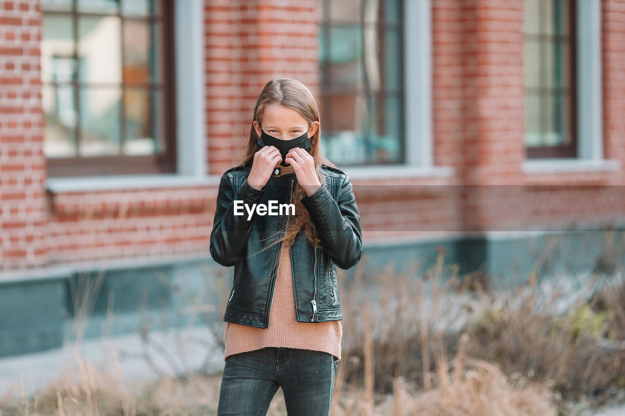 Girl wearing mask while standing outdoors