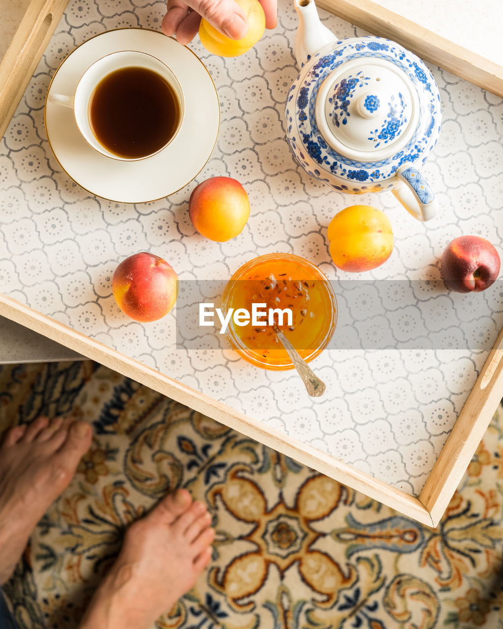 Woman's breakfast on a tray with tea, jam, fresh fruit. view from above