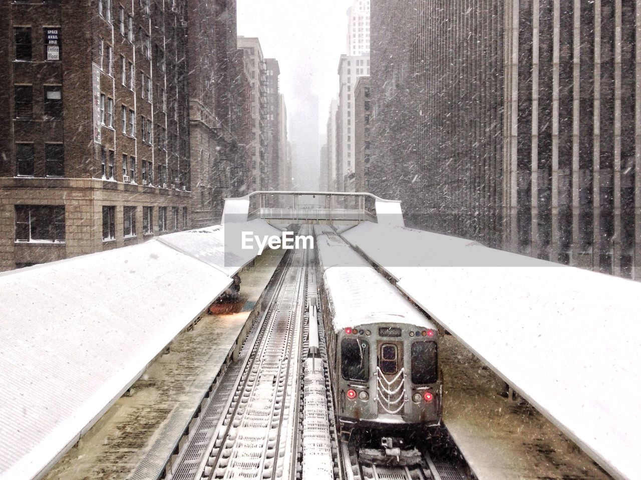 Train on railroad track in city during winter
