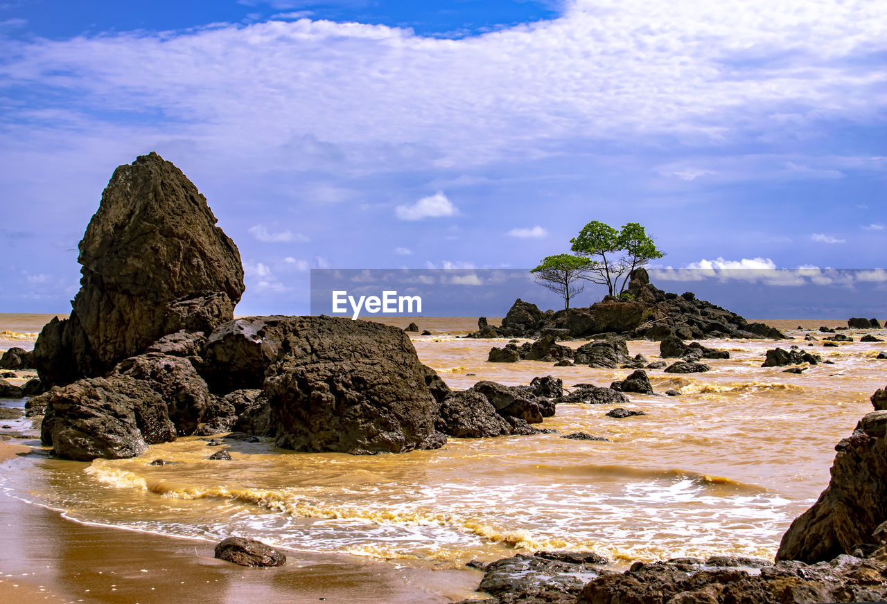 Rocks on beach against sky