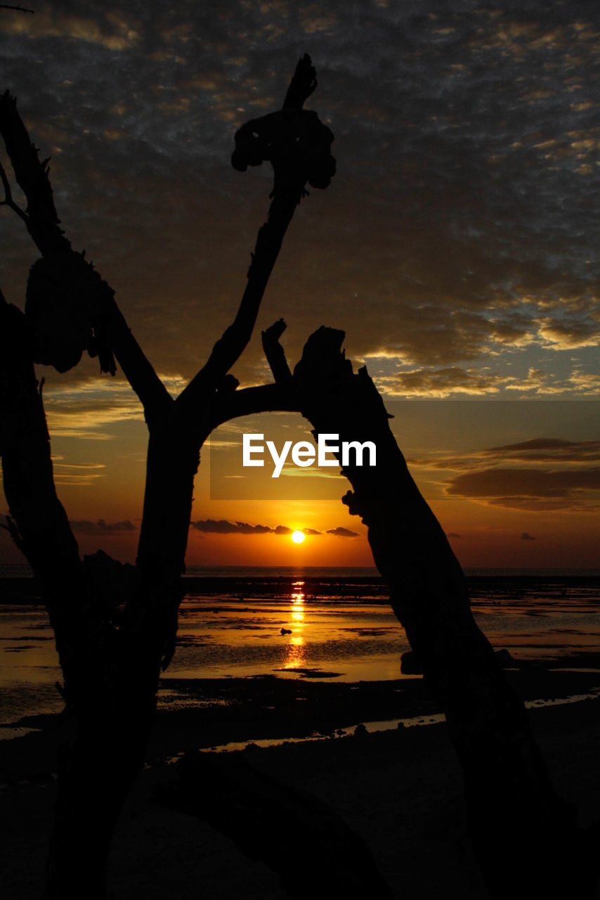 Silhouette of beach against sky during sunset