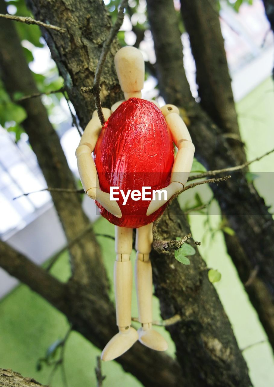 Close-up of toy holding easter egg on tree