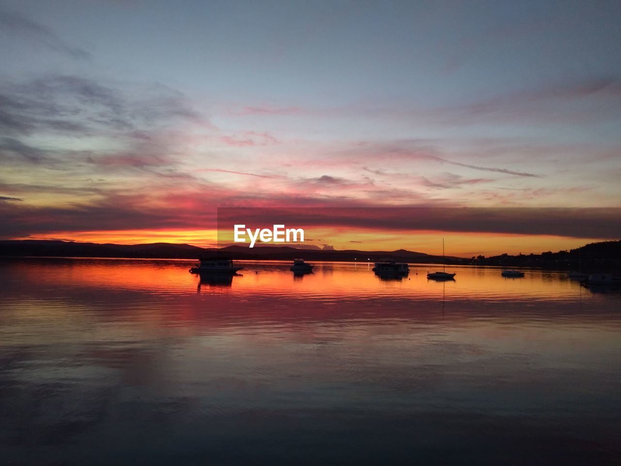 SCENIC VIEW OF LAKE AGAINST ORANGE SKY