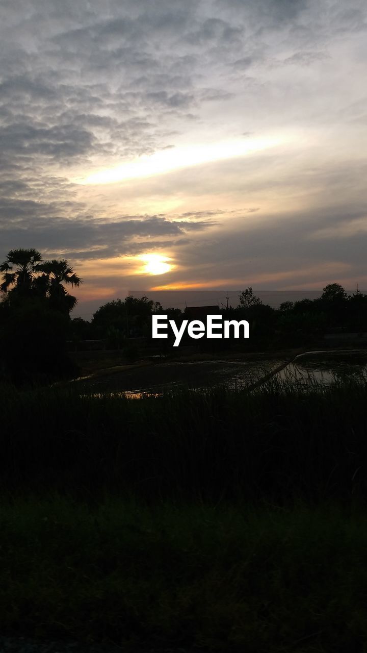 SCENIC VIEW OF SILHOUETTE FIELD AGAINST SKY AT SUNSET