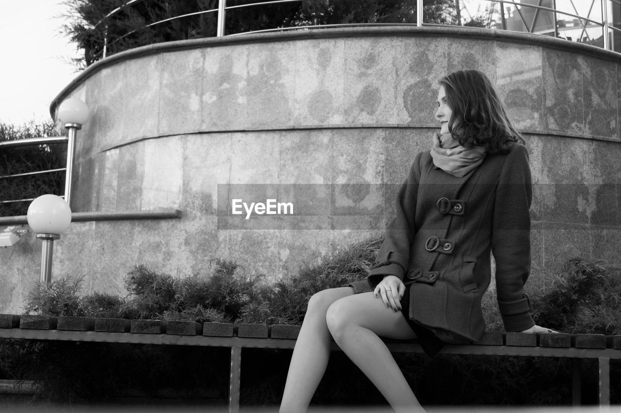 Woman sitting in front of building