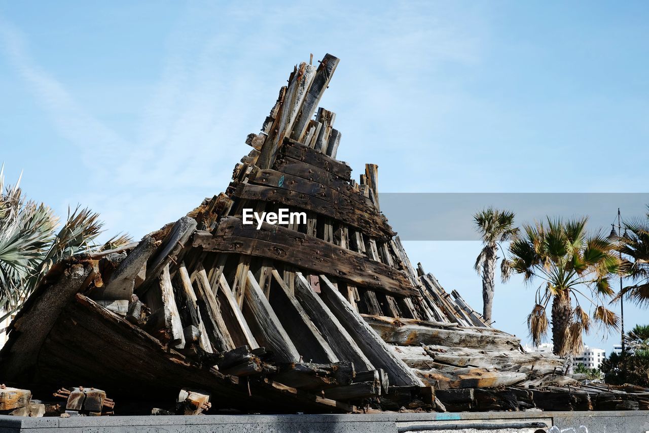 Wooden shipwreck against sky