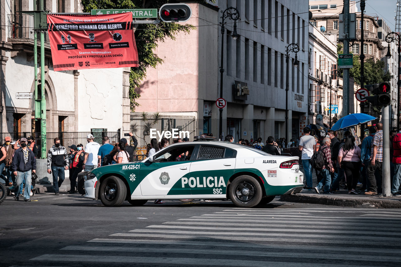 PEOPLE ON ROAD AGAINST BUILDINGS