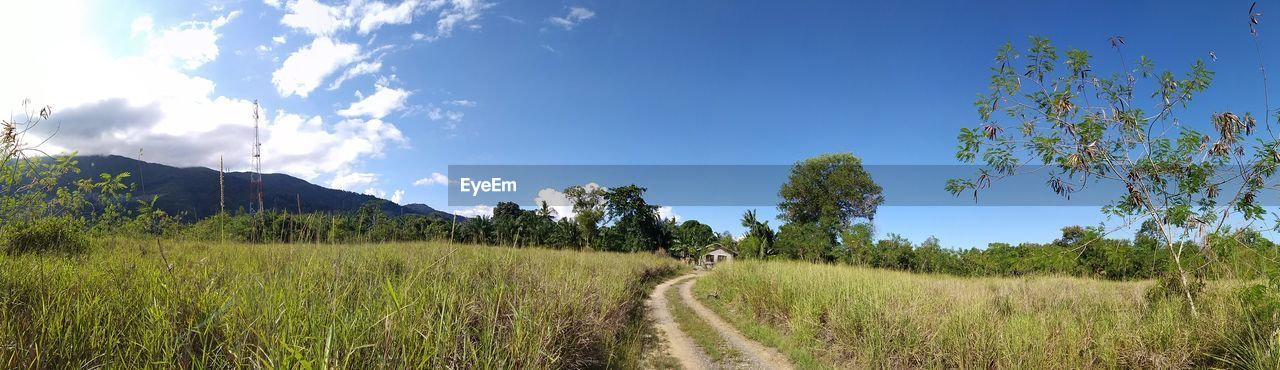 Panoramic shot of dirt road against sky