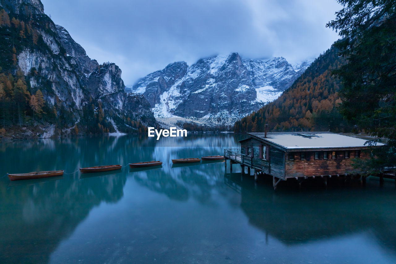 Scenic view of lake by snowcapped mountains against sky