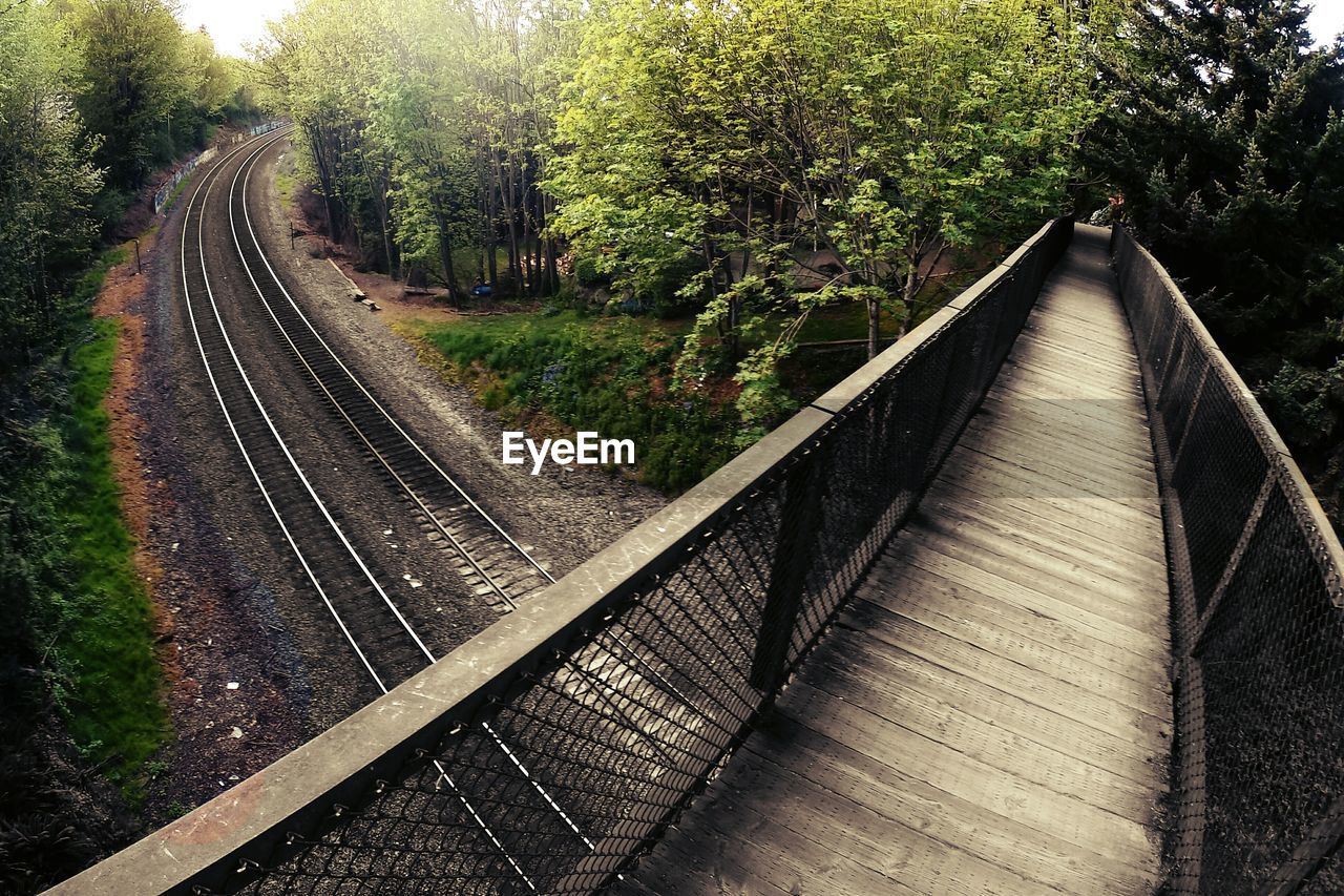 High angle view of footbridge over railroad tracks on field