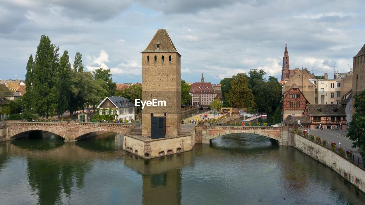 Arch bridge over river against buildings in city