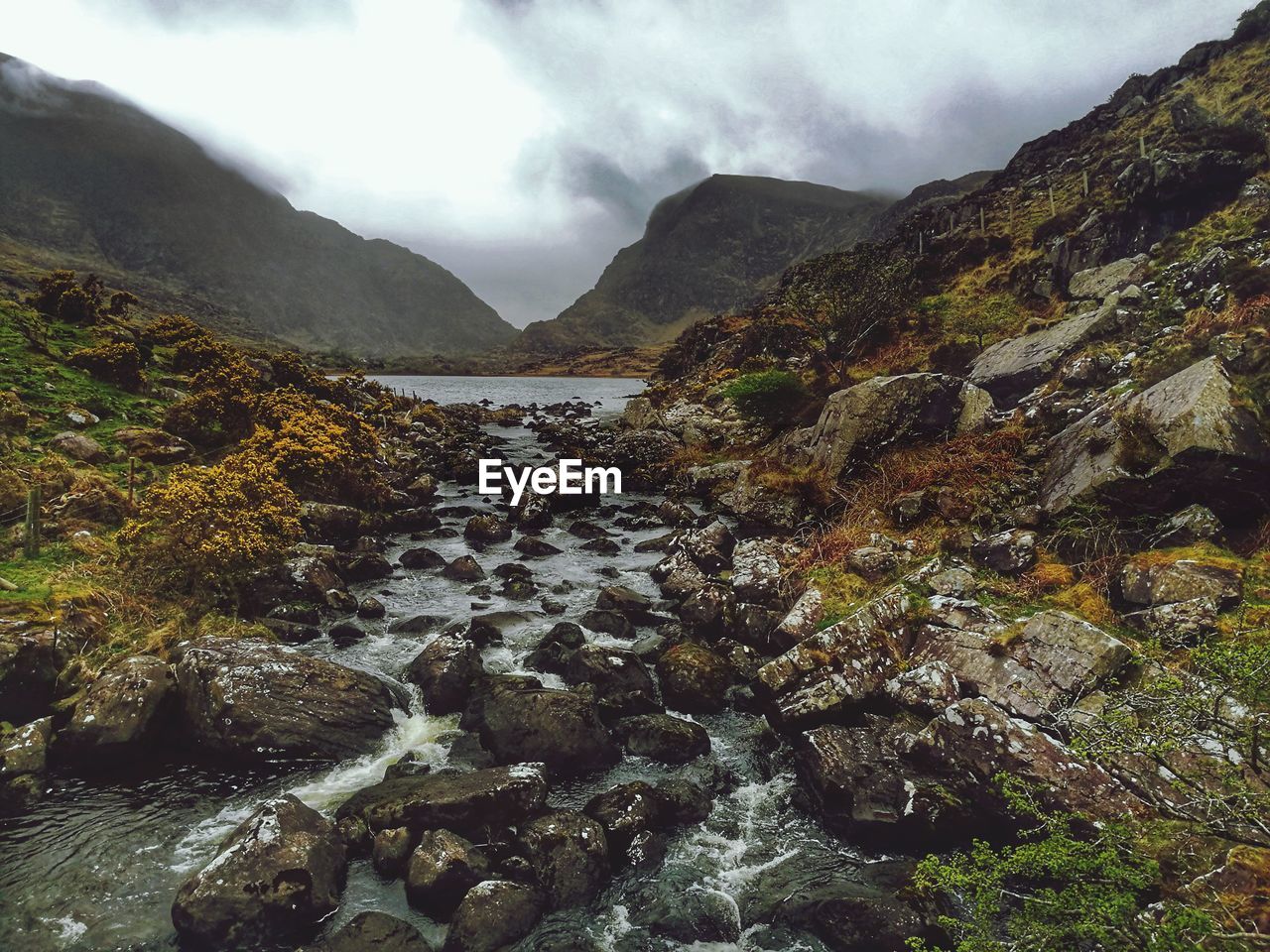 Scenic view of river amidst mountains against sky