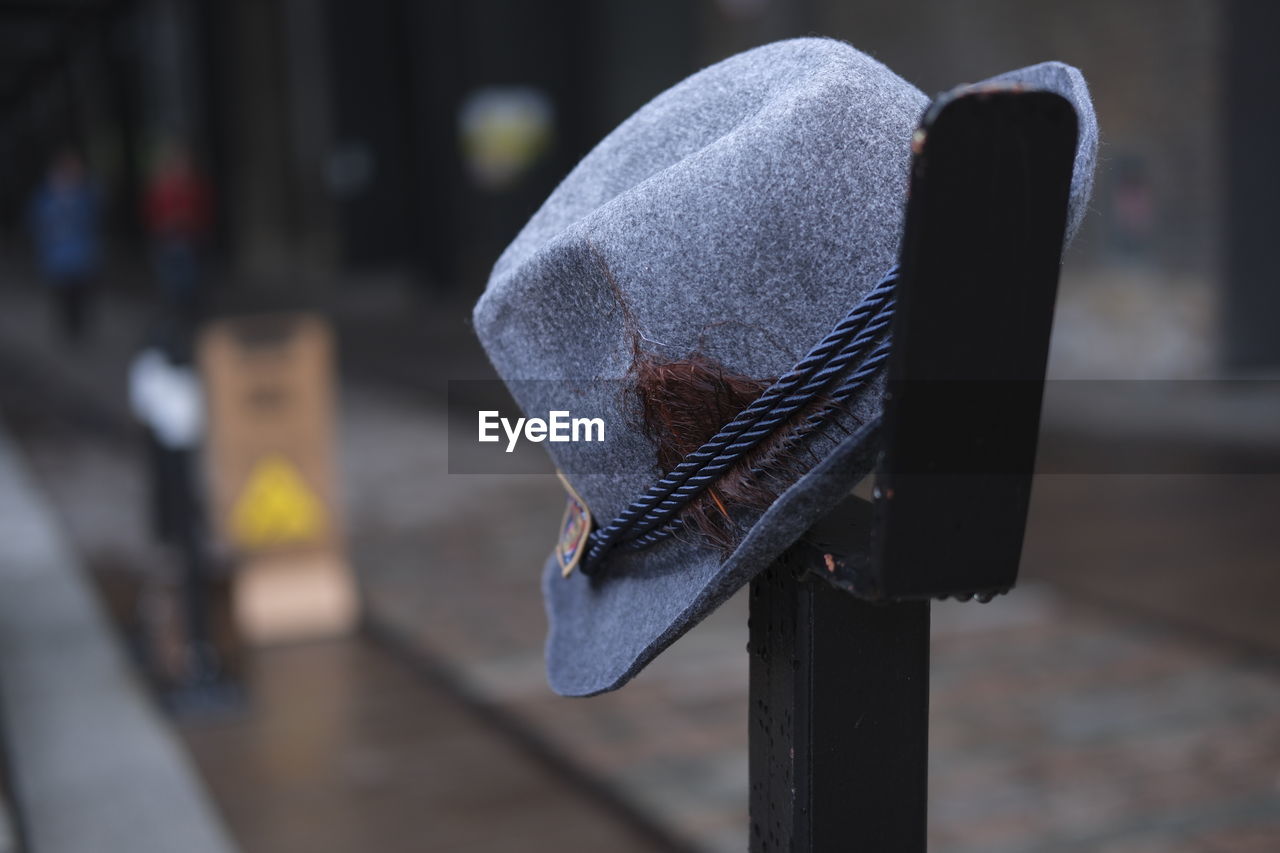 Close-up of hat perched on a railing