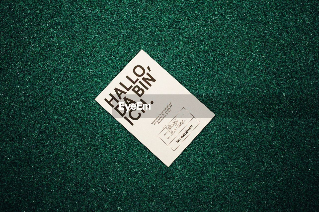 High angle view of paper with text on doormat
