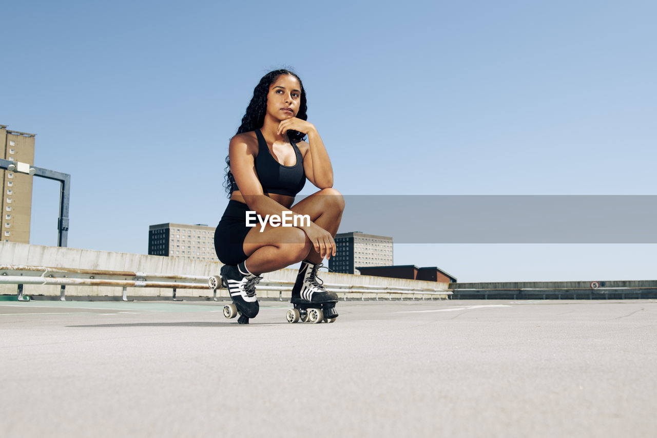 Young woman wearing roller skates, urban background.