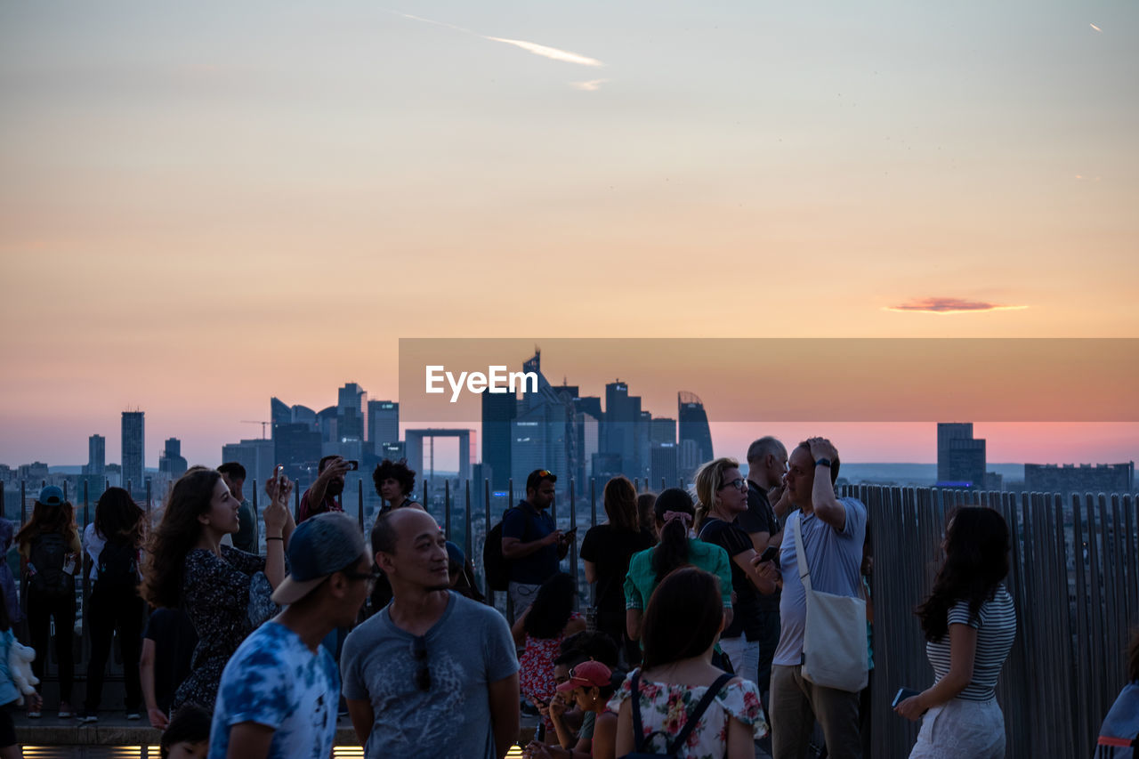 GROUP OF PEOPLE IN FRONT OF CITYSCAPE