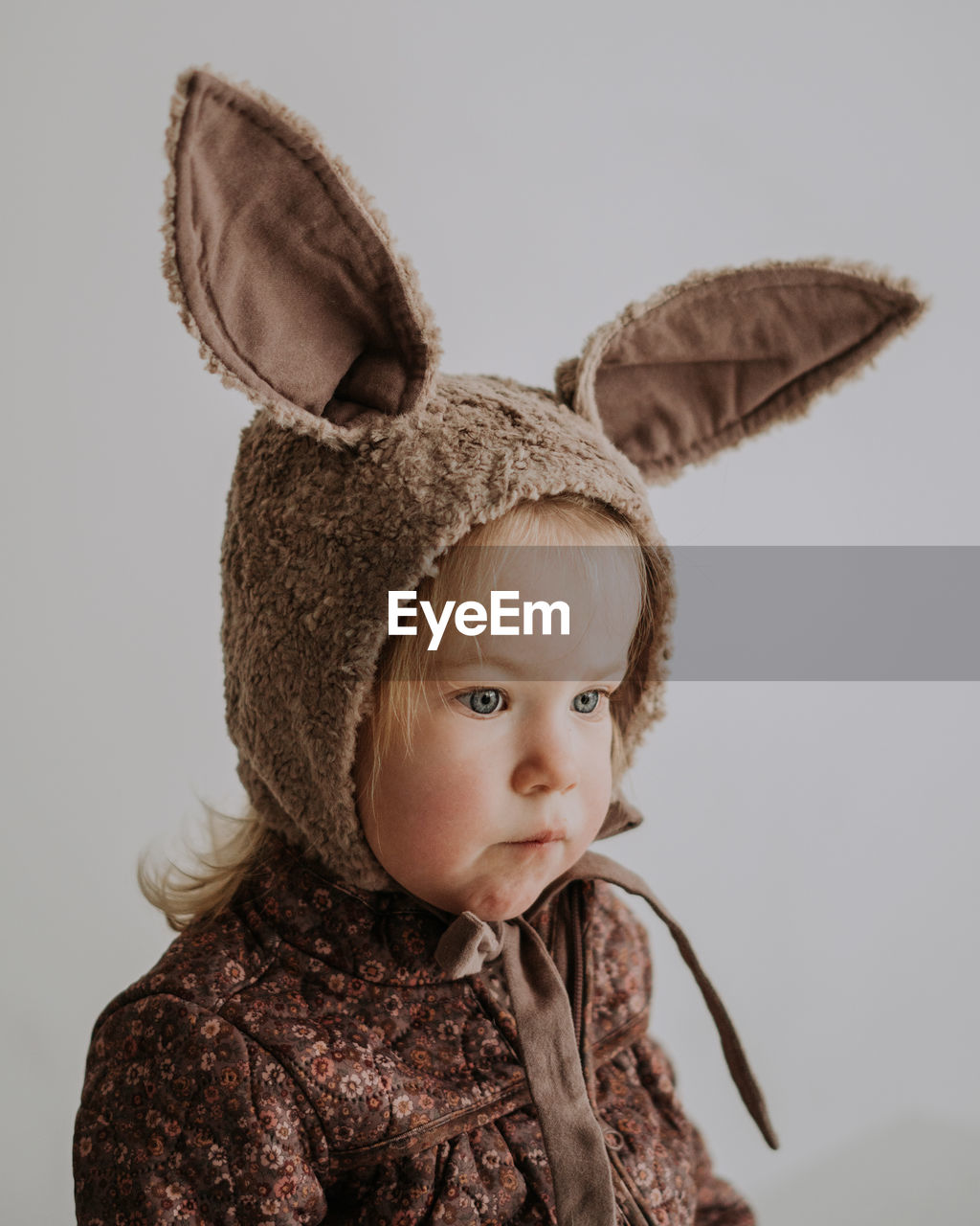 Close up portrait of toddler baby girl in funny hat with ears having fun