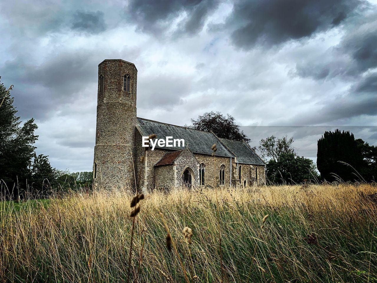 Abandoned building on field against sky