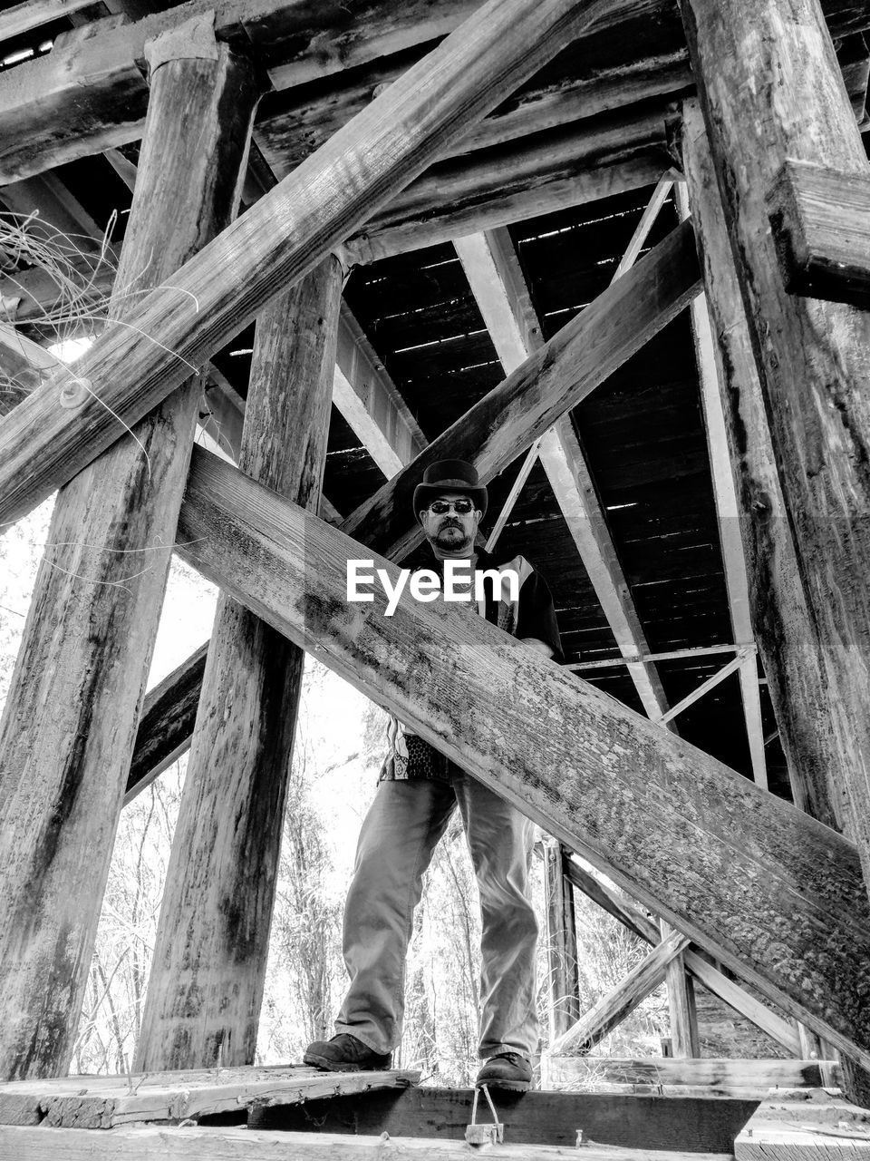 Low angle view of man standing below bridge