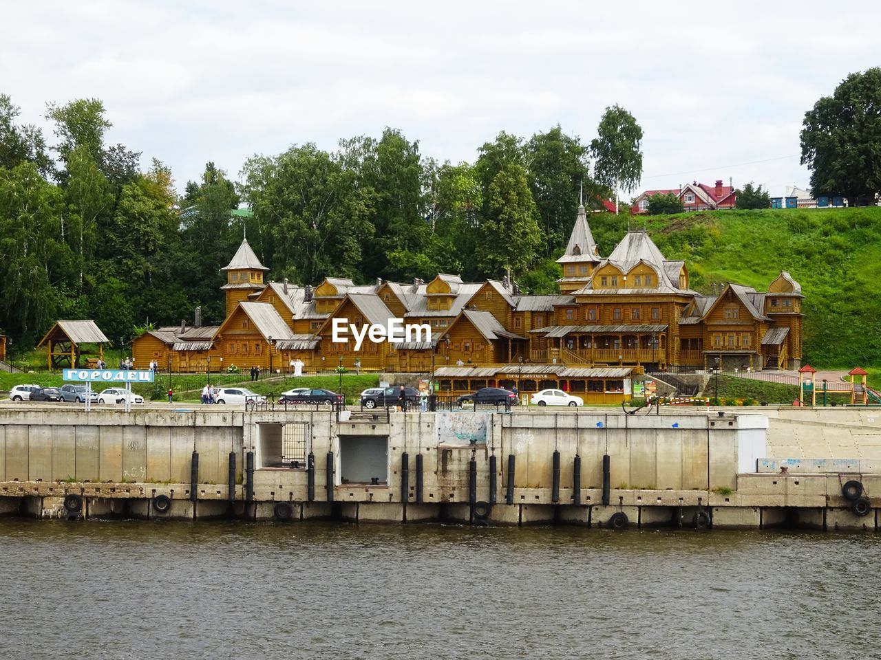 Houses by river and buildings against sky