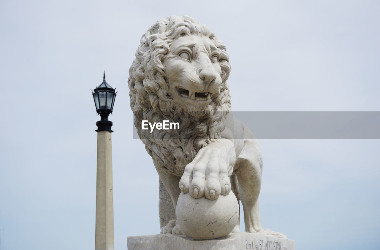 Low angle view of lion statue against sky