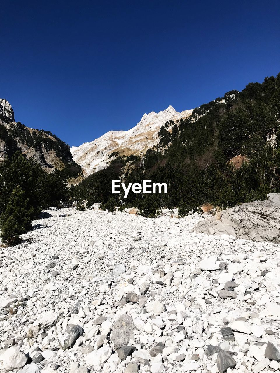 Scenic view of snowcapped mountains against clear blue sky