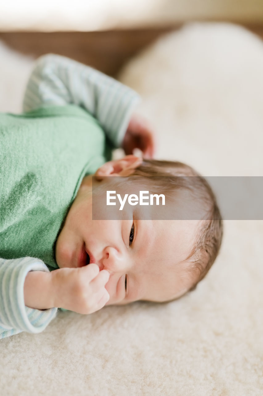 Cute baby lying on sofa at home