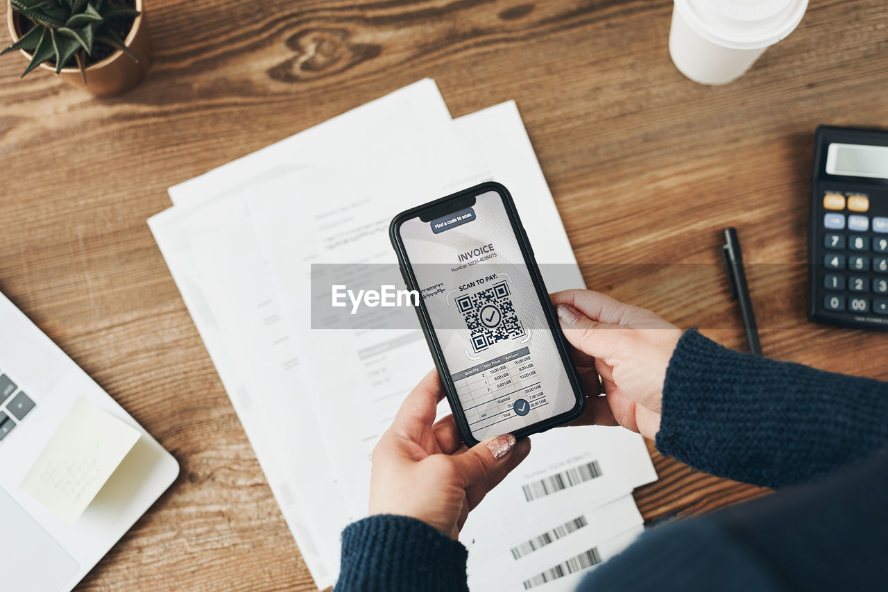 Paying invoice scanning qr code from document. using technology. qr scanner on smartphone. pay bills