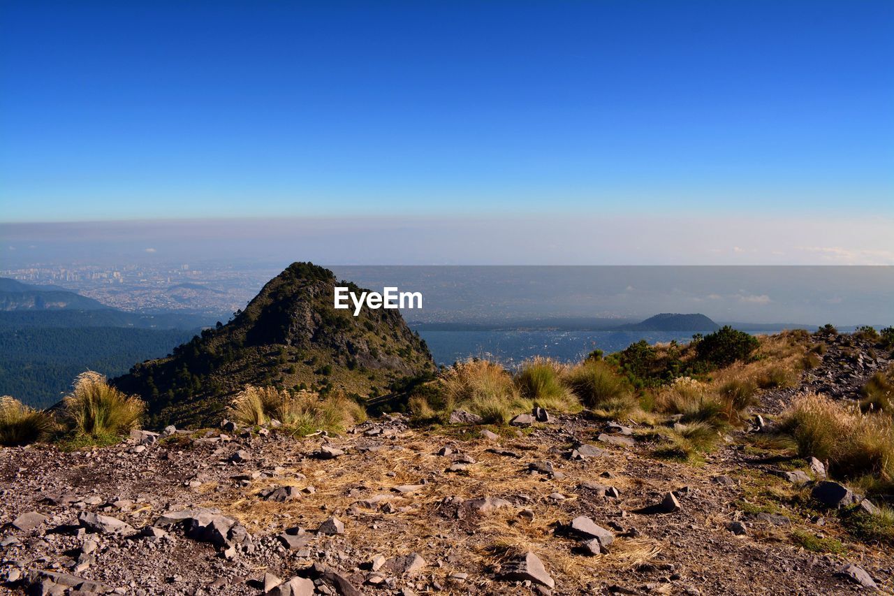 Scenic view of mountains against blue sky