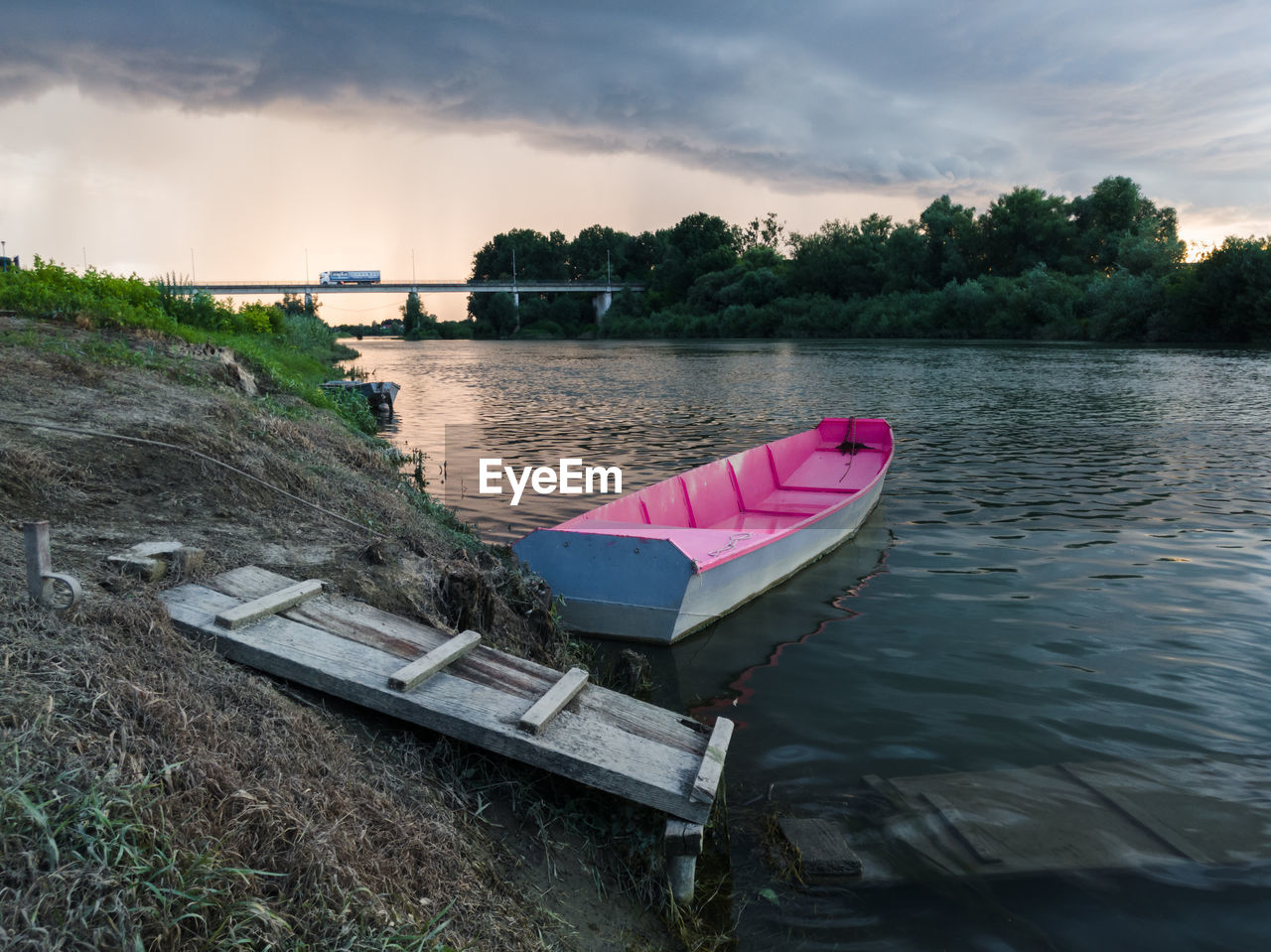 Boat moored on river against sky