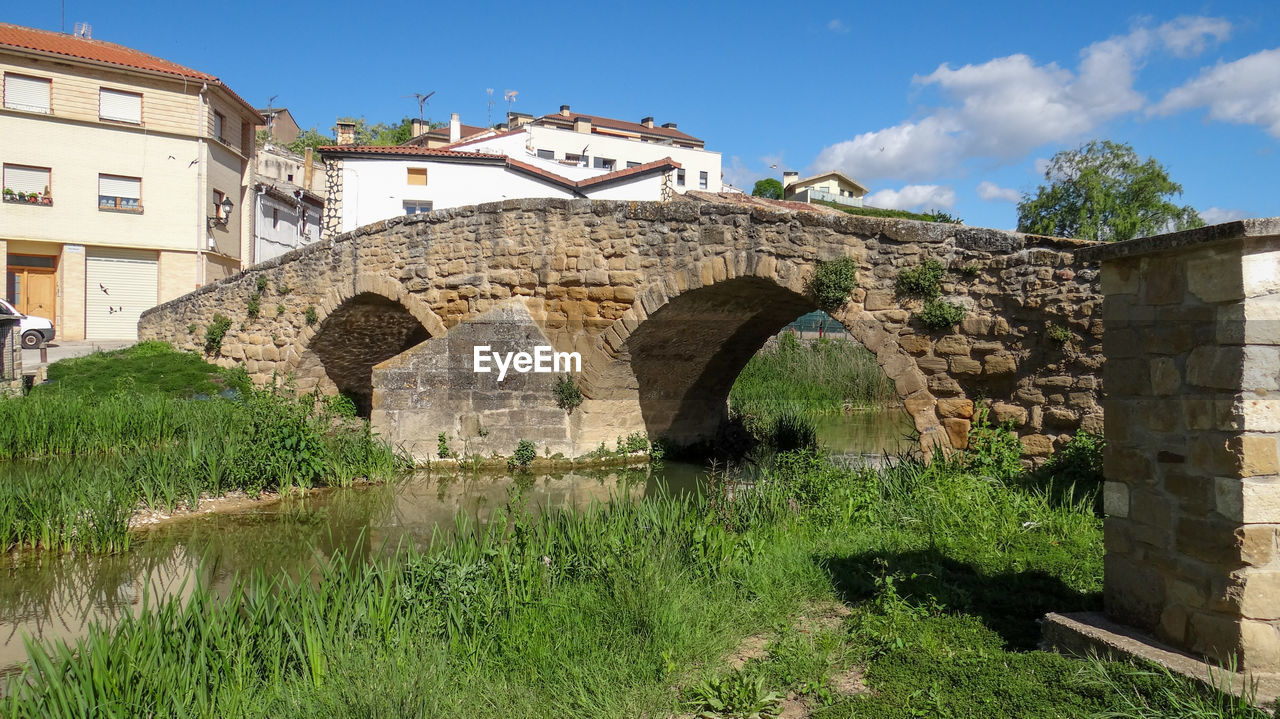 ARCH BRIDGE ON RIVER AGAINST SKY