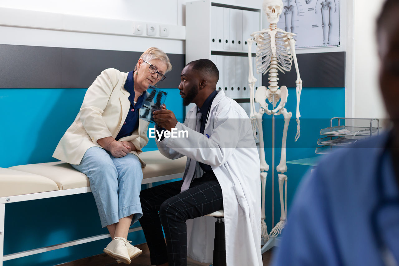 Male doctor showing x-ray image to patient at clinic