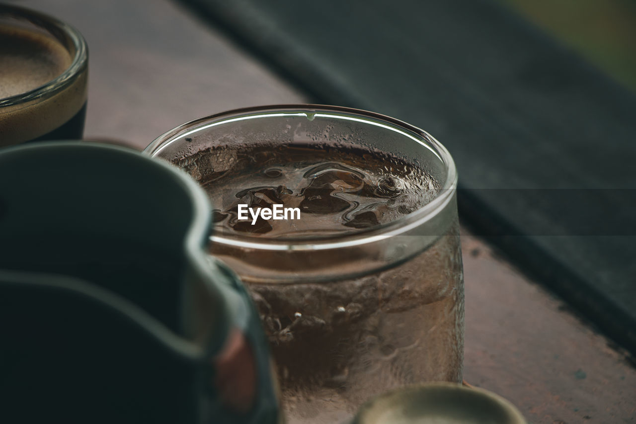 Extreme close up of the rim of a transparent glass cup of cool water.