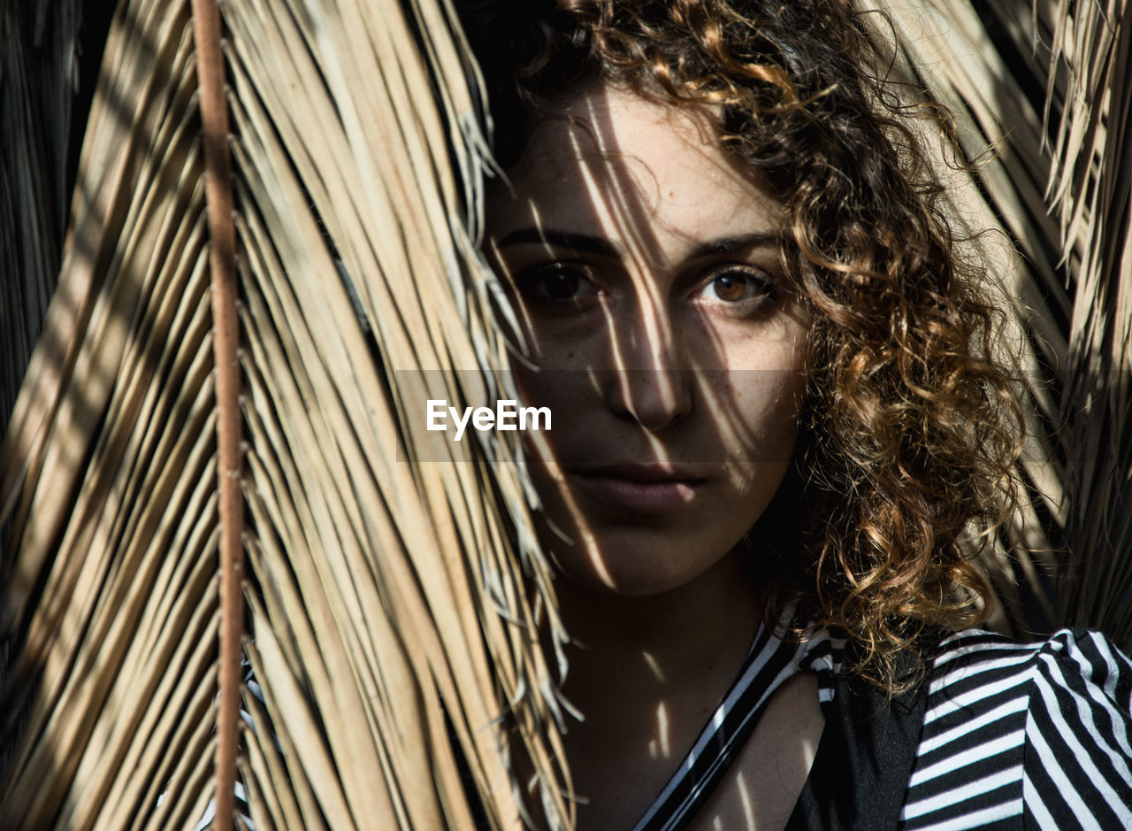 Portrait of young woman against trees