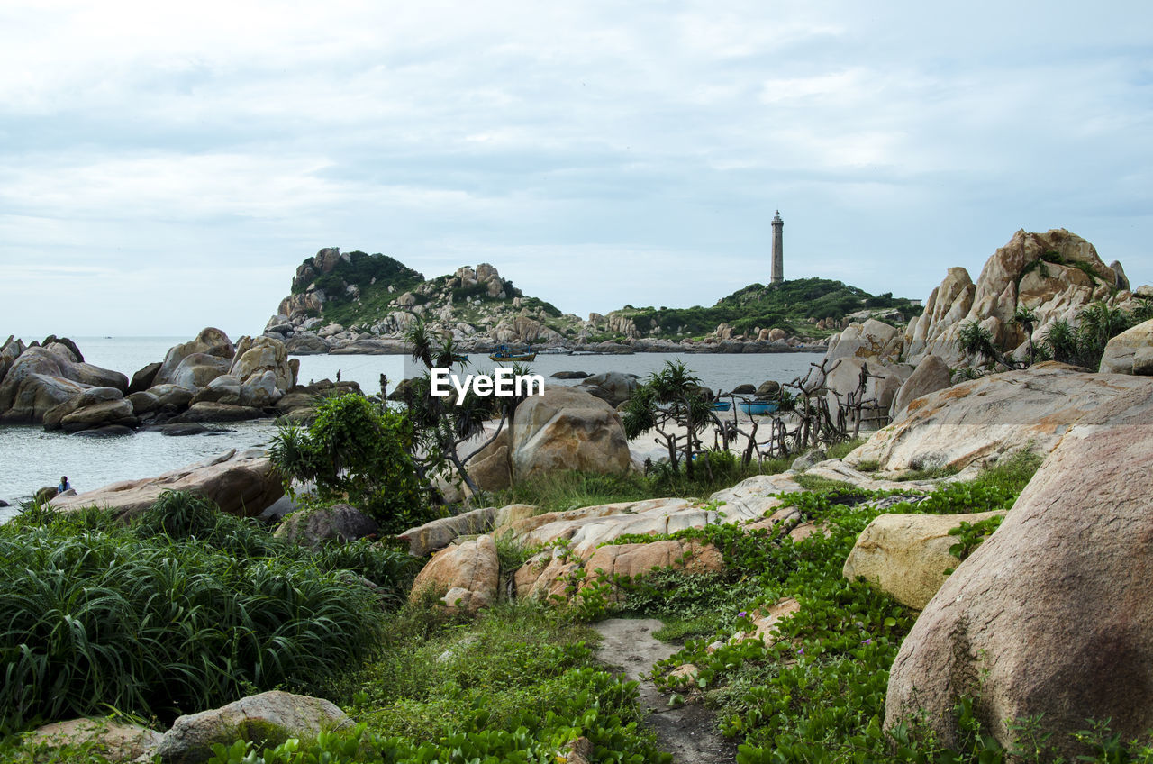 Rock formation by sea against sky