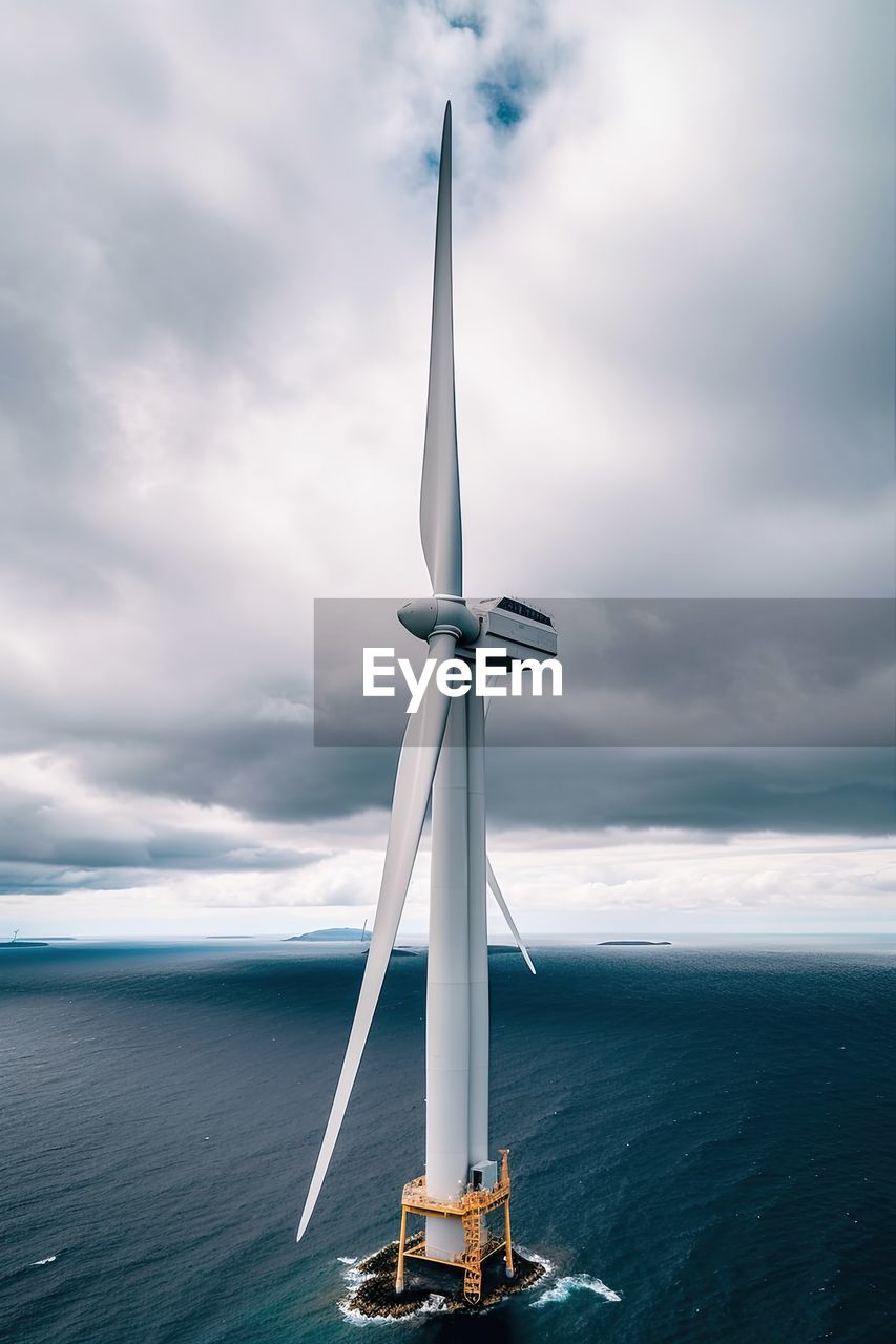 Drone aerial close up view of windmill in the ocean in a sunny day.ai generated
