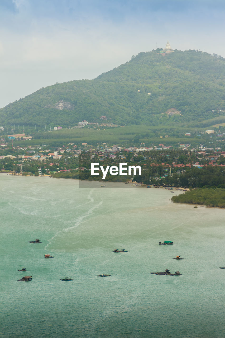 HIGH ANGLE VIEW OF DUCKS SWIMMING IN LAKE AGAINST MOUNTAINS