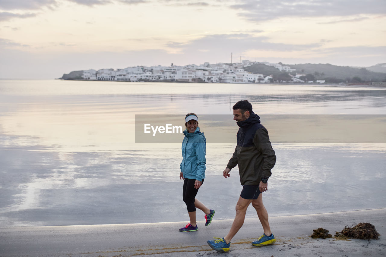 Couple walking near shore in morning at beach