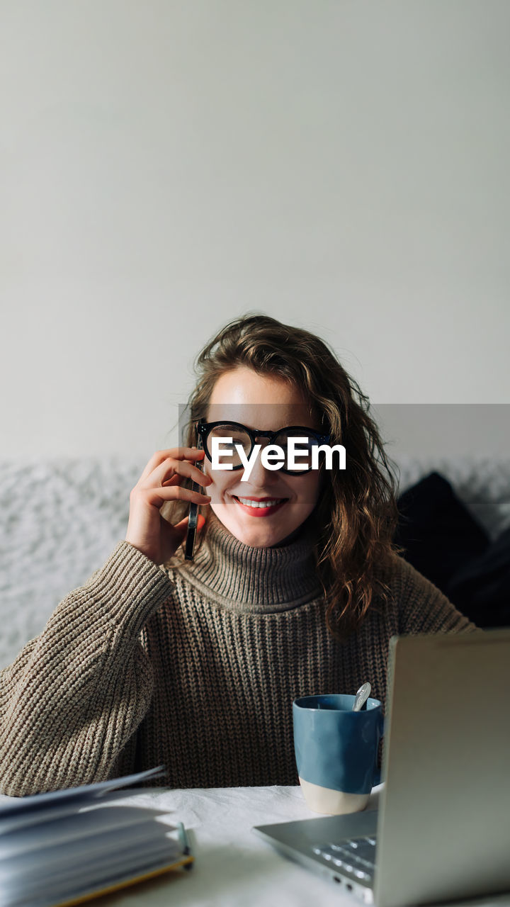 portrait of young woman using laptop while sitting on table