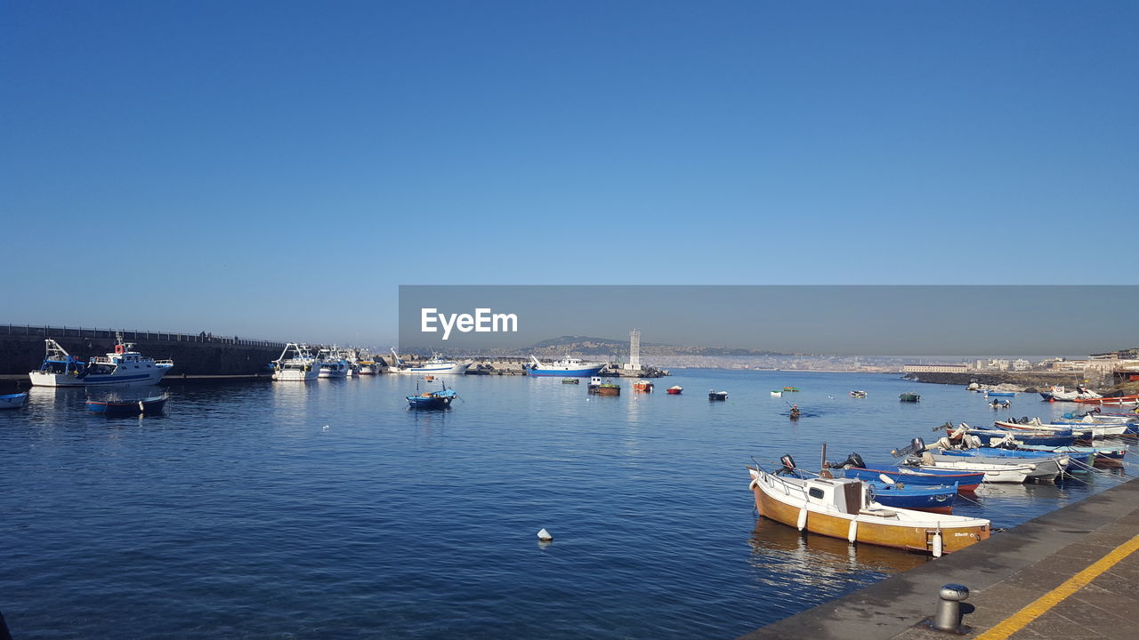 BOATS MOORED IN HARBOR