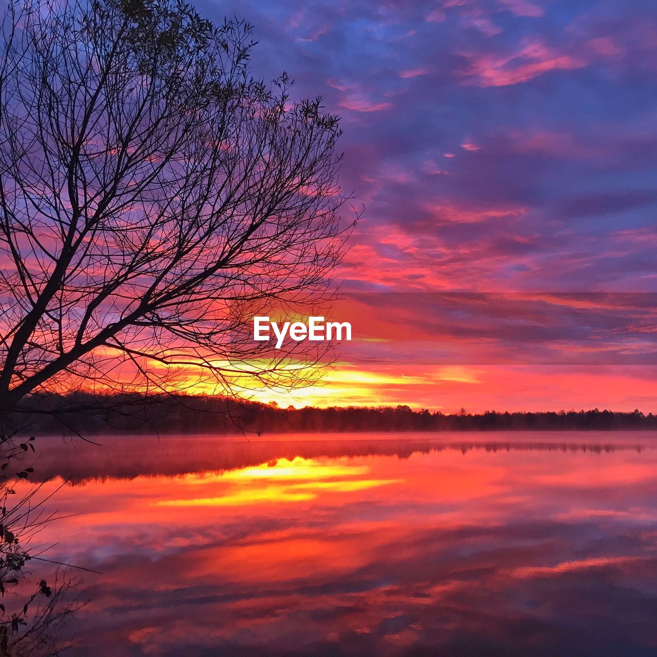 Scenic view of lake against orange sky