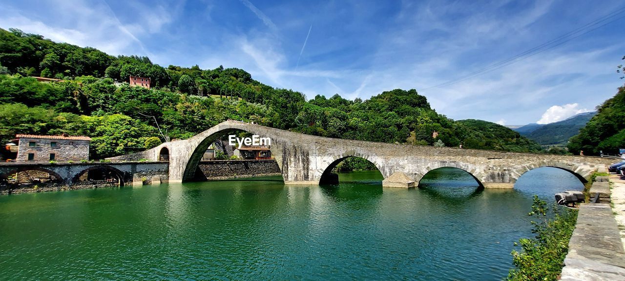 Arch bridge over river against sky. ponte della maddalena fiume serchio