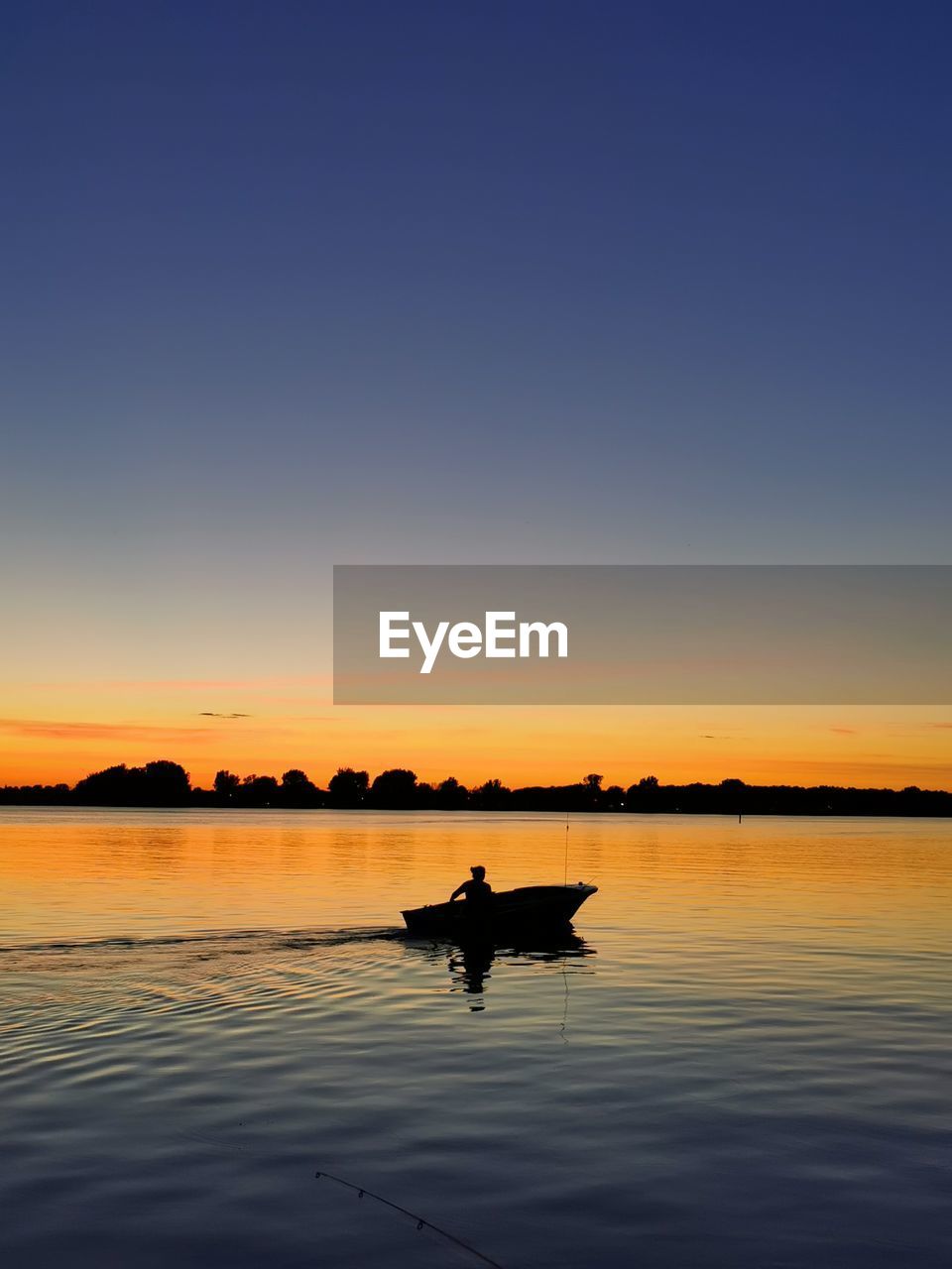 SILHOUETTE MAN IN BOAT AGAINST SKY DURING SUNSET