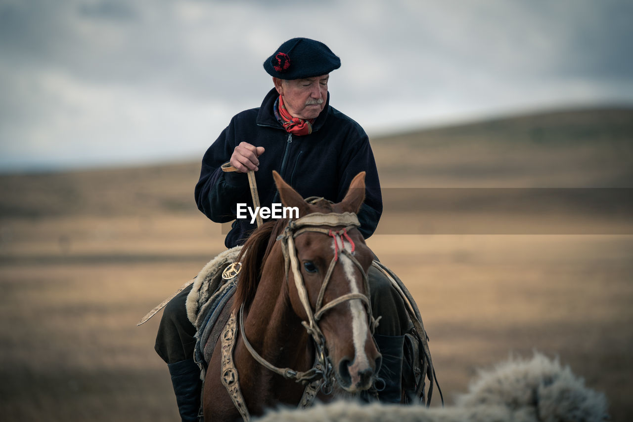 Mature man riding horse on land