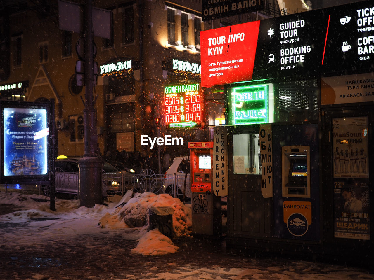 ILLUMINATED STREET AMIDST BUILDINGS DURING WINTER