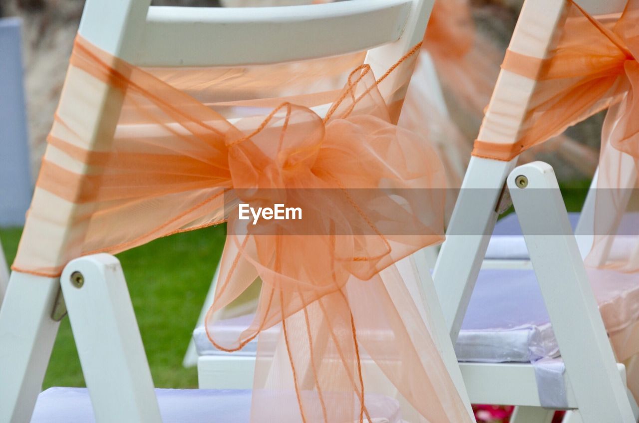 Close up of fabric tied on chairs at wedding
