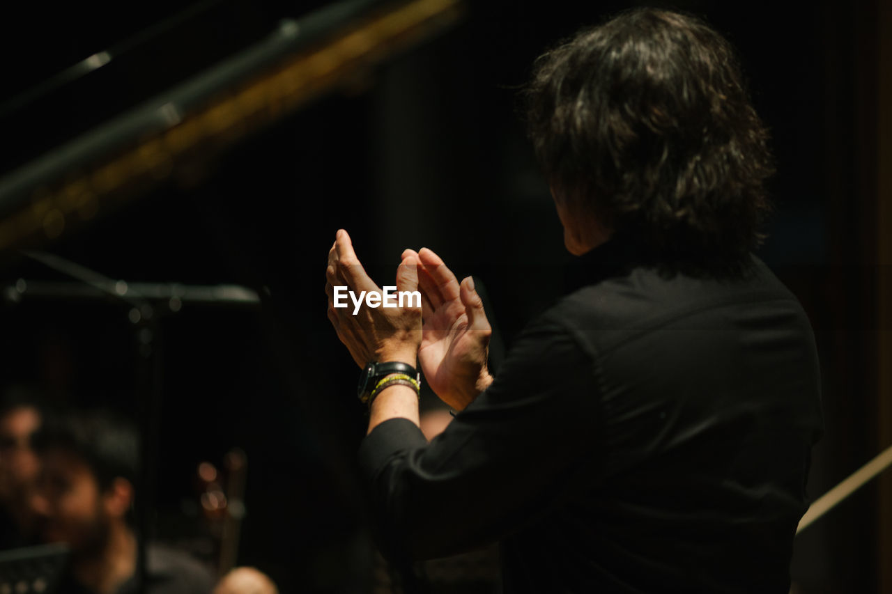 Side view of man applauding