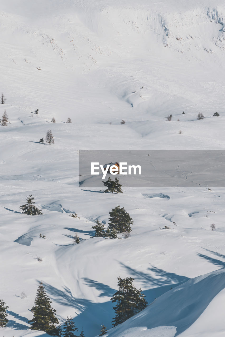 A picturesque view of a remote house in the snowcapped french alps mountains