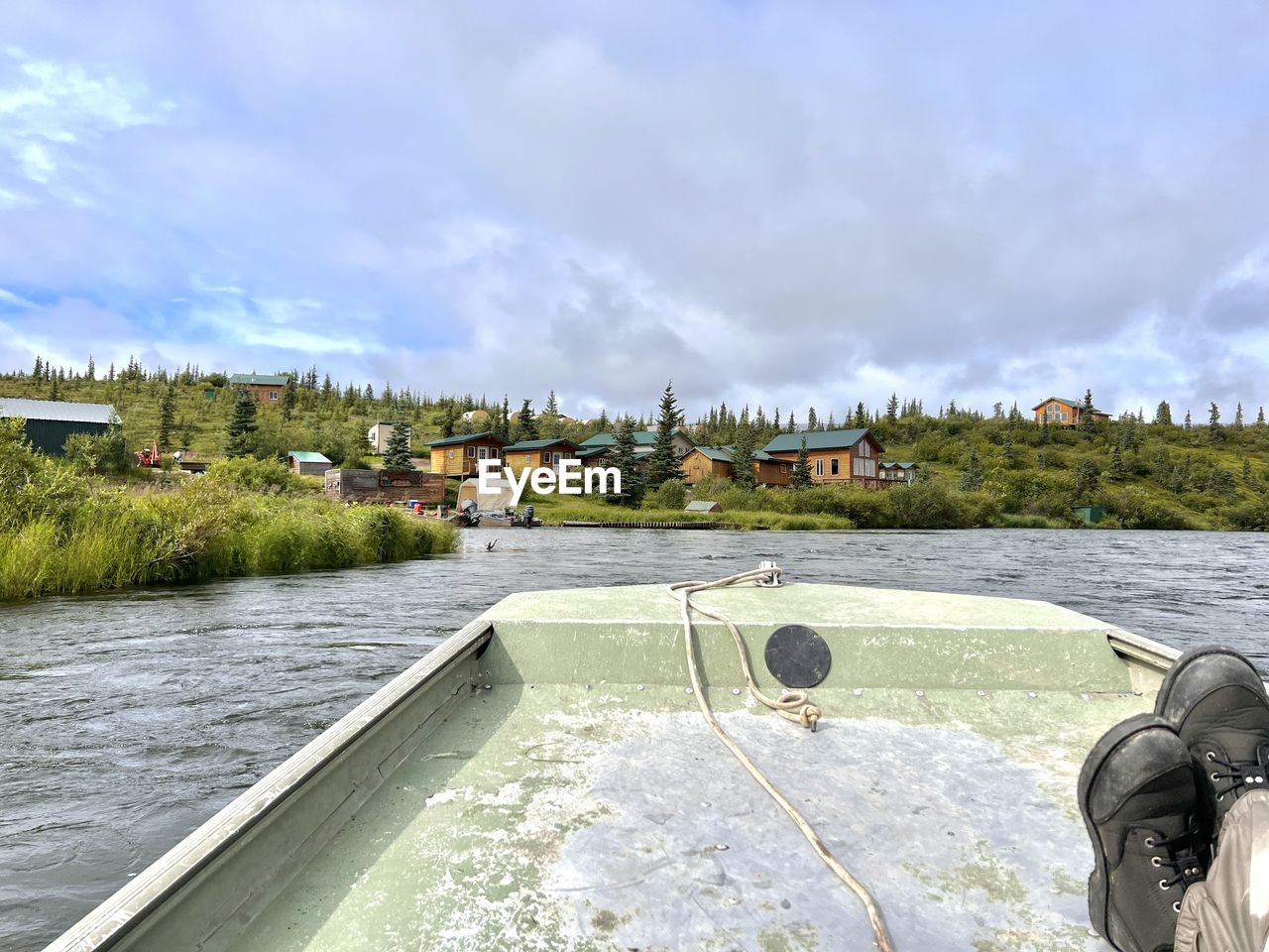 Scenic view of alaska fishing lodge on river from a boat 
