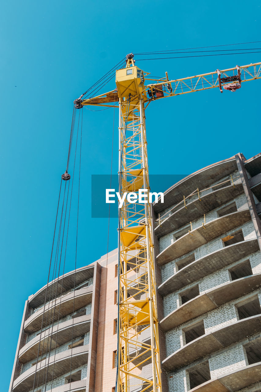 LOW ANGLE VIEW OF CRANE AGAINST SKY